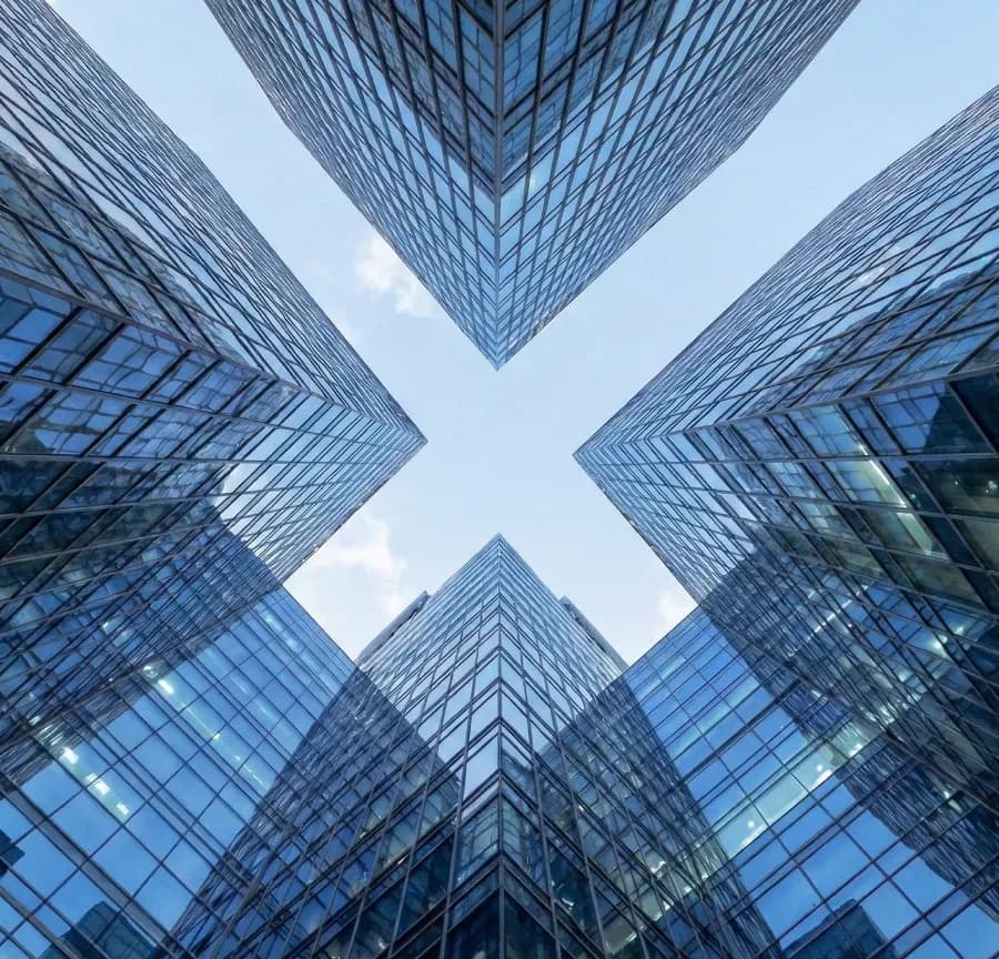 Vista de baixo para cima de edifícios corporativos de vidro convergindo para o céu
